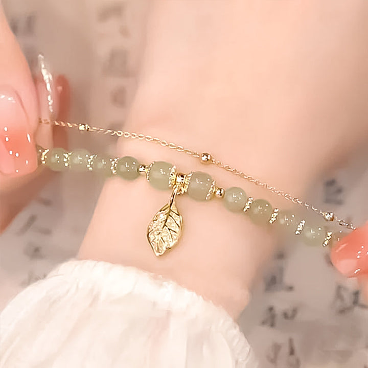"Dame armband i grön jade med gulddekor, elegant smycke, grön sten och gyllene detaljer, perfekt accessoar för kvinnor."