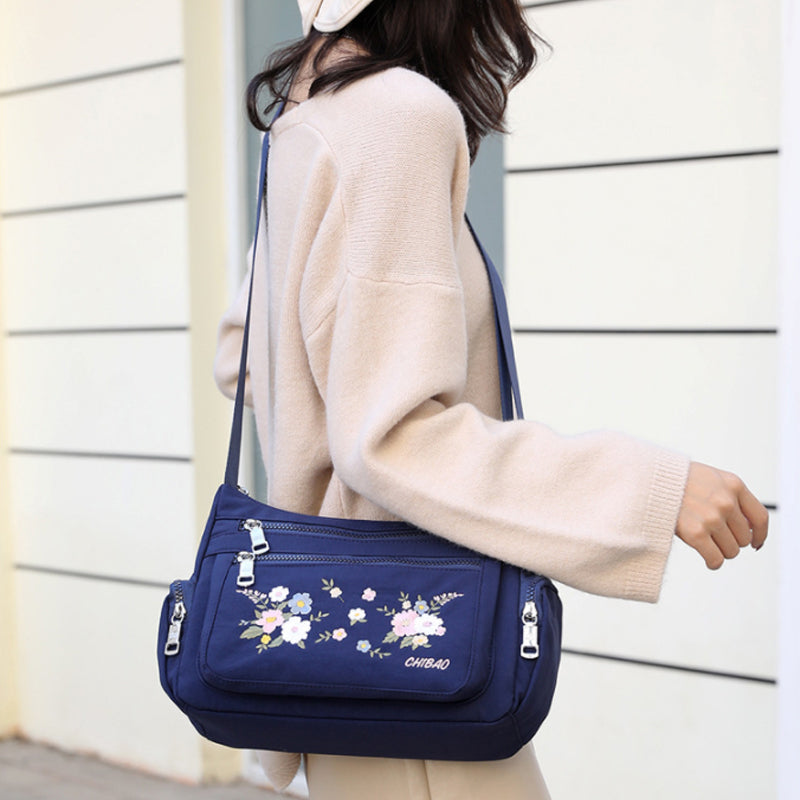 "Damer Axelväska i Nylon med Blombroderi, rymlig och stilren, justerbar axelrem, finns i flera färger."