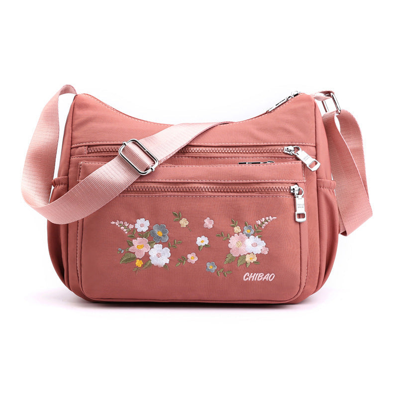 "Damer Axelväska i Nylon med Blombroderi, rymlig och stilren, justerbar axelrem, finns i flera färger."