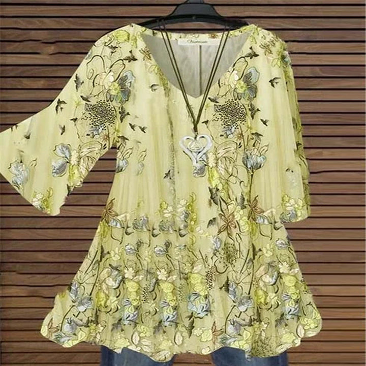 "Damer elegant blus med flare ärmar, V-ringning, kaki färg, visad från sidan för att framhäva sofistikerad design."