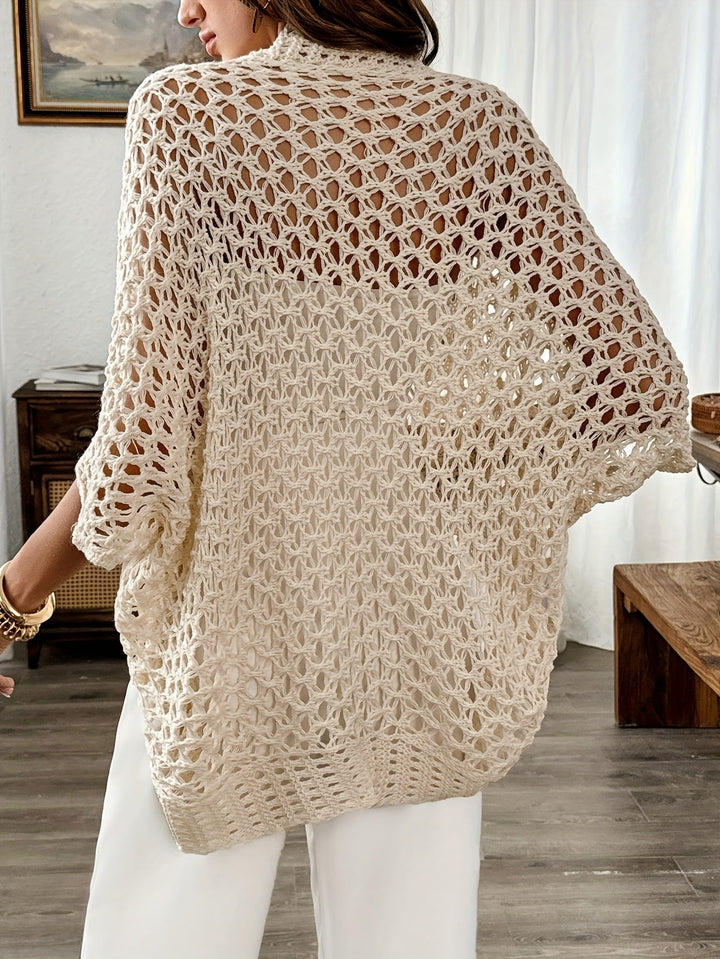 Modell bär den öppna, draperade damkoftan i beige, stylad för en avslappnad vinterlook.