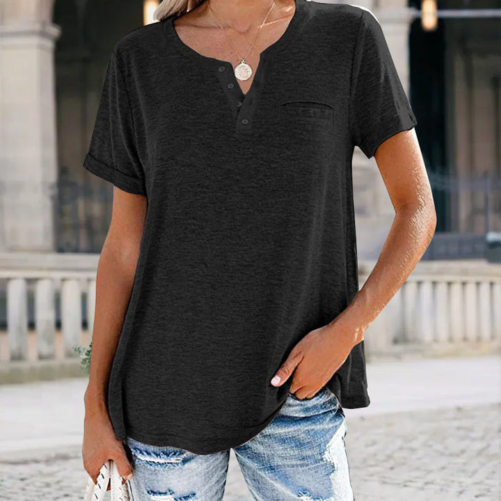 "Damer V-ringad T-shirt i bomull med fickdetalj, elegant design, visar fickan och V-ringningen, finns i flera färger."