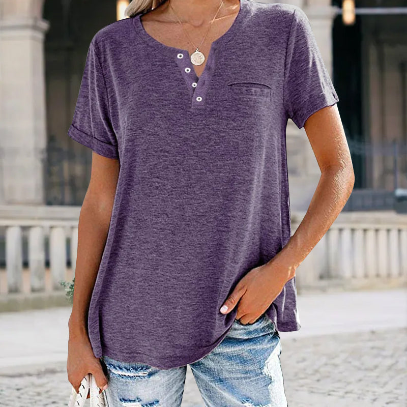 "Damer V-ringad T-shirt i bomull med fickdetalj, elegant design, visar fickan och V-ringningen, finns i flera färger."