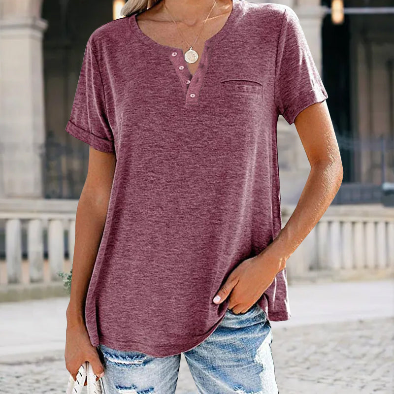 "Damer V-ringad T-shirt i bomull med fickdetalj, elegant design, visar fickan och V-ringningen, finns i flera färger."