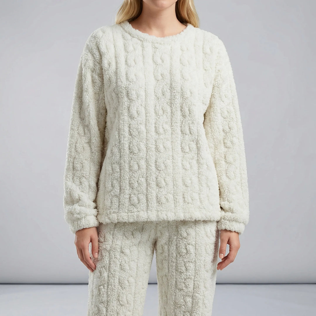 Kvinna kopplar av i det bekväma dam-pyjamasset Amy med långa ärmar, idealiskt som nattplagg.