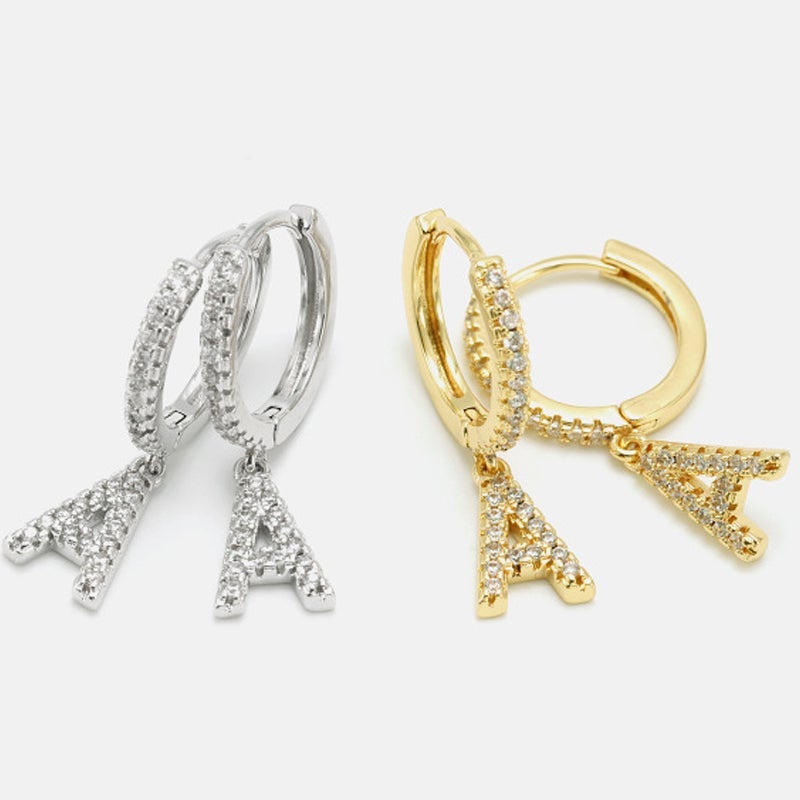 "Damhalsband i alfabetdesign med kubisk zirkon, elegant glansig finish, perfekt accessoar, visas i silver eller gyllene."