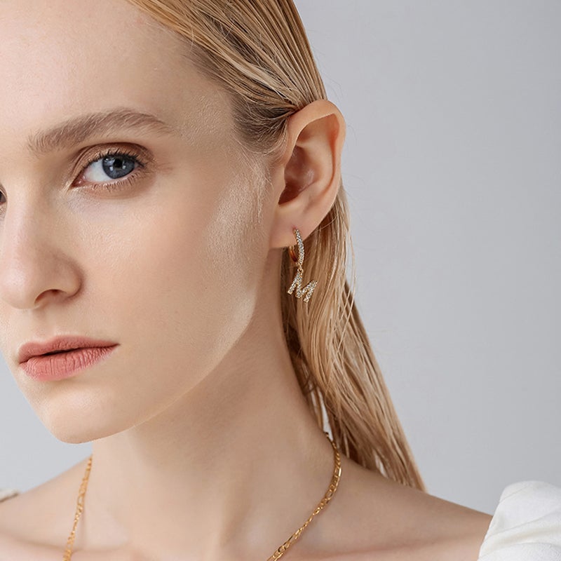 "Damhalsband i alfabetdesign med kubisk zirkon, elegant glansig finish, perfekt accessoar, visas i silver eller gyllene."