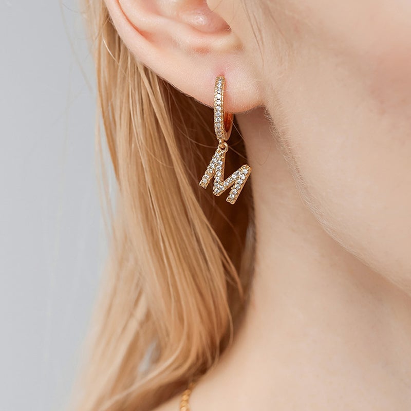 "Damhalsband i alfabetdesign med kubisk zirkon, elegant glansig finish, perfekt accessoar, visas i silver eller gyllene."
