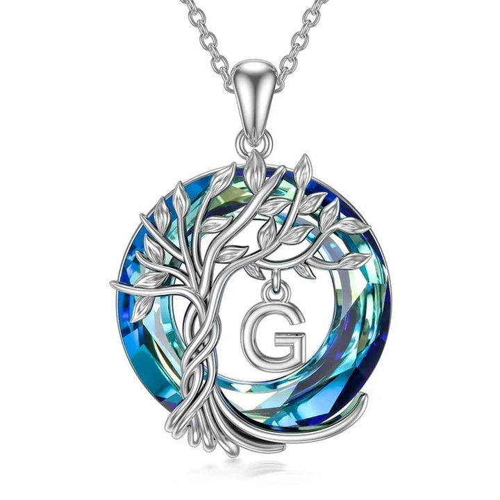 "Damhalsband i silver med livets träd och blå kristall, eleganta och symboliska smycken för unik kvinnlig stil."