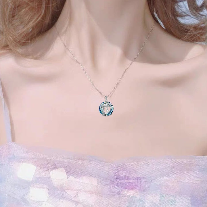 "Damhalsband i silver med livets träd och blå kristall, eleganta och symboliska smycken för unik kvinnlig stil."