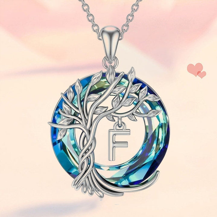 "Damhalsband i silver med livets träd och blå kristall, eleganta och symboliska smycken för unik kvinnlig stil."