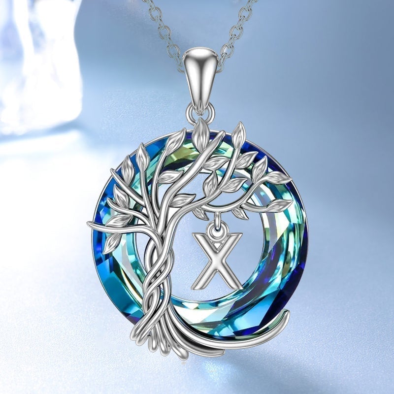 "Damhalsband i silver med livets träd och blå kristall, eleganta och symboliska smycken för unik kvinnlig stil."