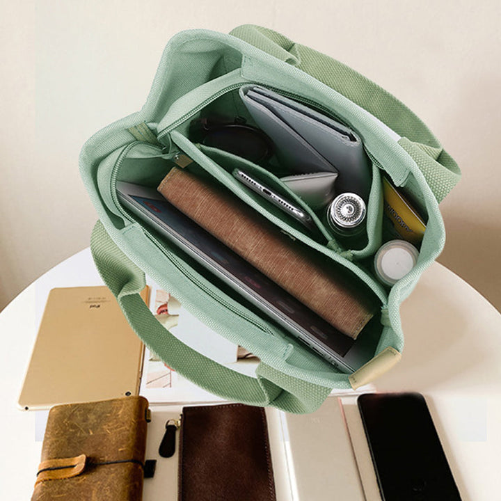 "Damhögkapacitets-canvasväska med flerficksdesign, färgstark och slitstark med säkra dragkedjor. Praktisk accessoar."