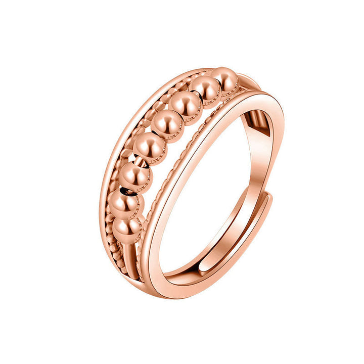 Damring med roterande kulor i guld, platina eller roséguld. Eleganta bollar minskar stress, perfekt kvinnligt tillbehör.