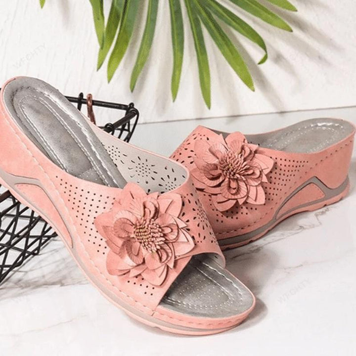 "Damsandaler med ihåliga snidade kilklackar, beige färg, öppen tå och blommiga detaljer för modern stil och komfort."