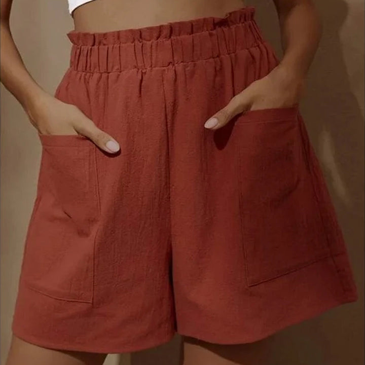 Damshorts med hög midja i bomull, framifrån. Perfekta för sommaren, med justerbar dragsko och två snedställda fickor.