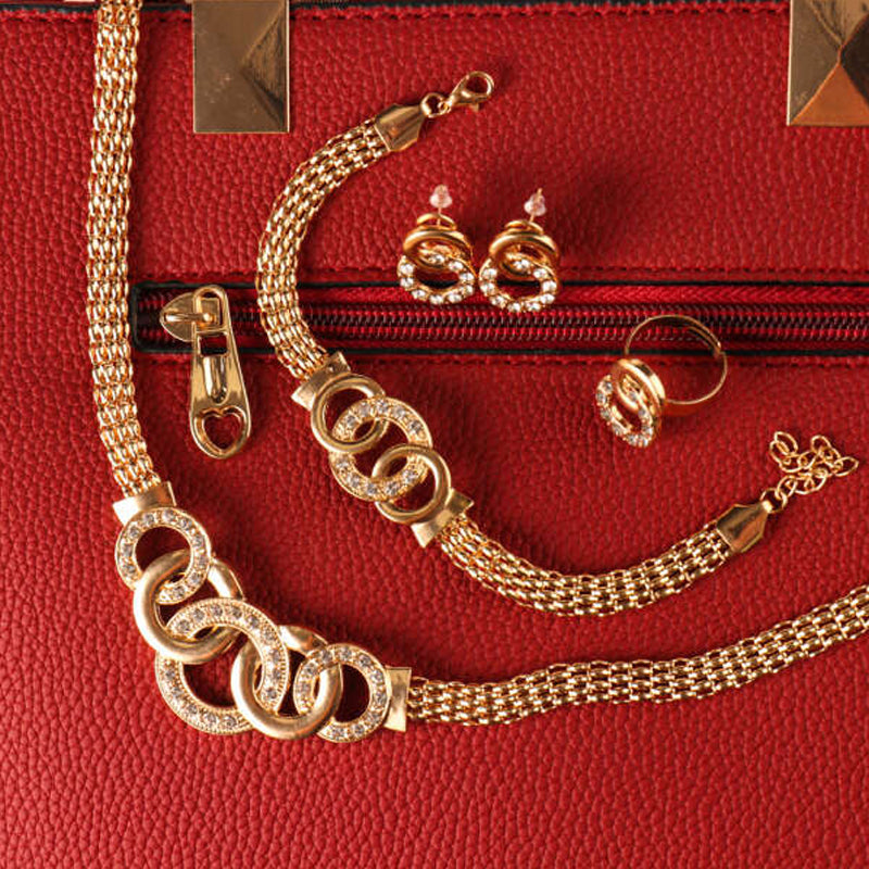 "Damsmyckesset i guld och silver med zirconia, innehåller halsband, armband, örhängen och ring, elegant design."