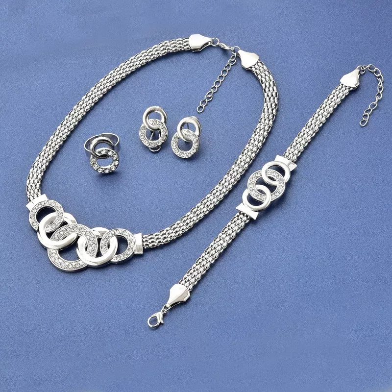"Damsmyckesset i guld och silver med zirconia, innehåller halsband, armband, örhängen och ring, elegant design."