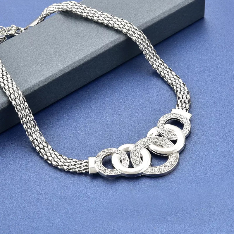 "Damsmyckesset i guld och silver med zirconia, innehåller halsband, armband, örhängen och ring, elegant design."