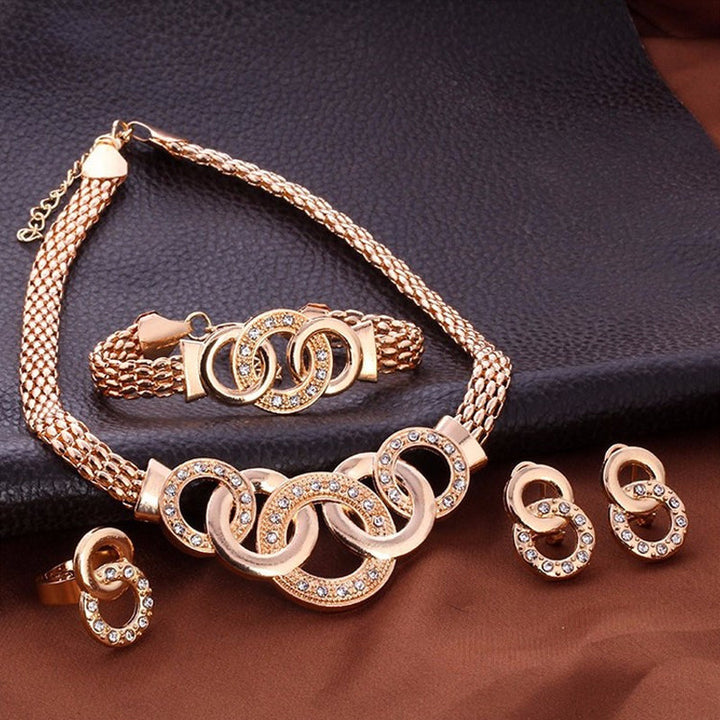 "Damsmyckesset i guld och silver med zirconia, innehåller halsband, armband, örhängen och ring, elegant design."