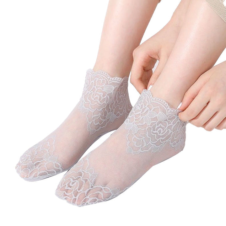 Damsockor i spetsnät, eleganta och andningsbara, med spetsbroderi i sofistikerad design, perfekt för både vardag och fest.