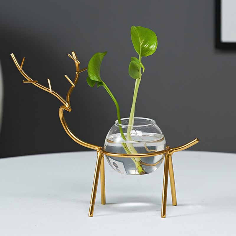 "Dekorativ hjort vas i järn och glas, elegant design med metalltråd i form av hjortar, perfekt för modern inredning."