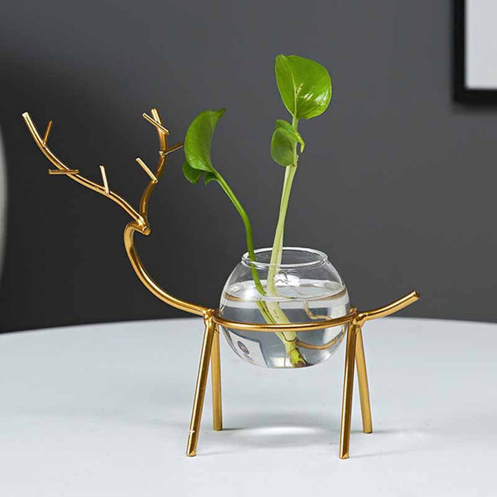 "Dekorativ hjort vas i järn och glas, elegant design med metalltråd i form av hjortar, perfekt för modern inredning."