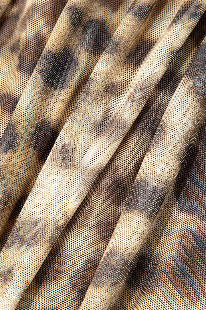 Närbild av tyget på Kvinnors meshtopp med livfullt leopardmönster och halterneck, visar detaljer och textur.