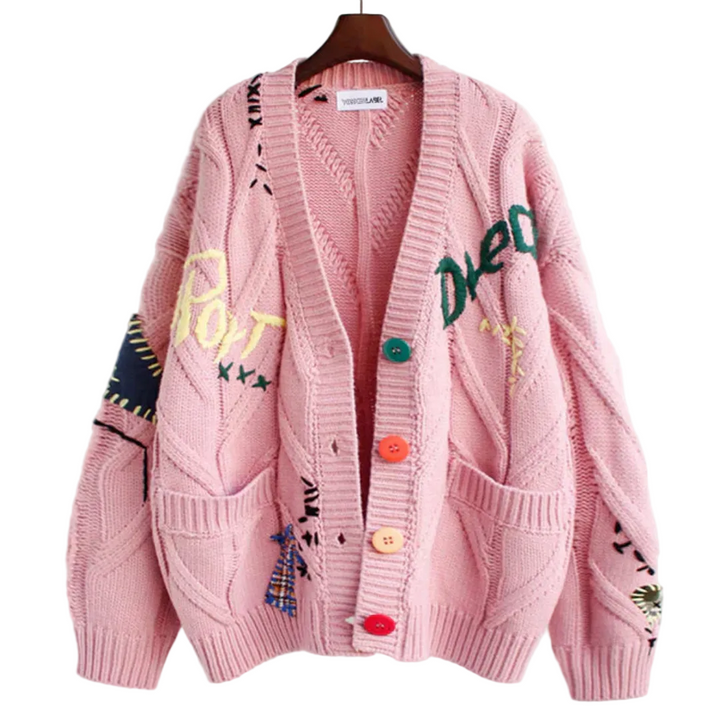 Detaljbild av en damkofta med lång ärm, med intrikata broderier och bekväm stickad textur. Perfekt för höstmode.