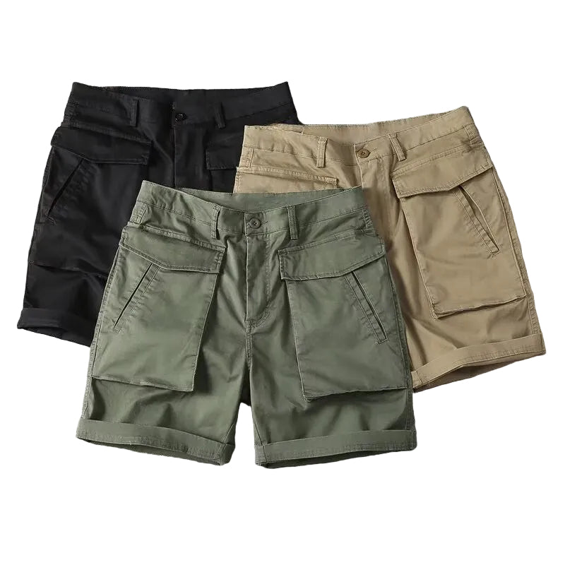 Herr i beige taktiska cargoshorts, reser sig från huk för att visa rörelsefrihet, utomhusmiljö.