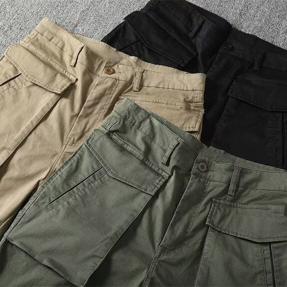 Detaljerad bild av spännen och knäppning på herrars taktiska cargoshorts, framhäver kvalitet och design.
