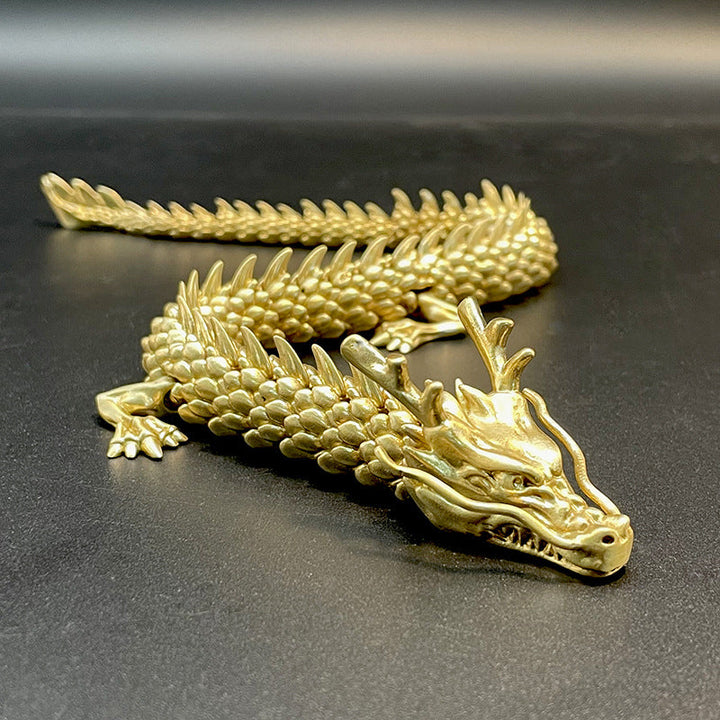 "Detaljerad gyllene drake i mässing för dekoration med rörliga leder, fångar ljus och erbjuder mystisk charm för hemmet."