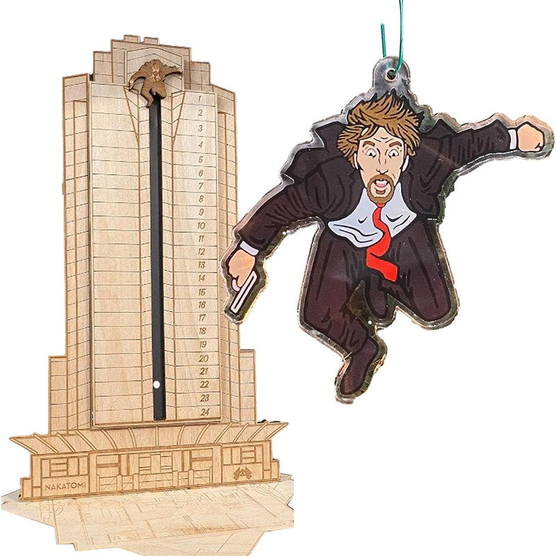 "Detaljerad trä Adventskalender med Die Hard-motiv, visar Hans Gruber faller från brunblå Nakatomi Plaza, roterbar design."