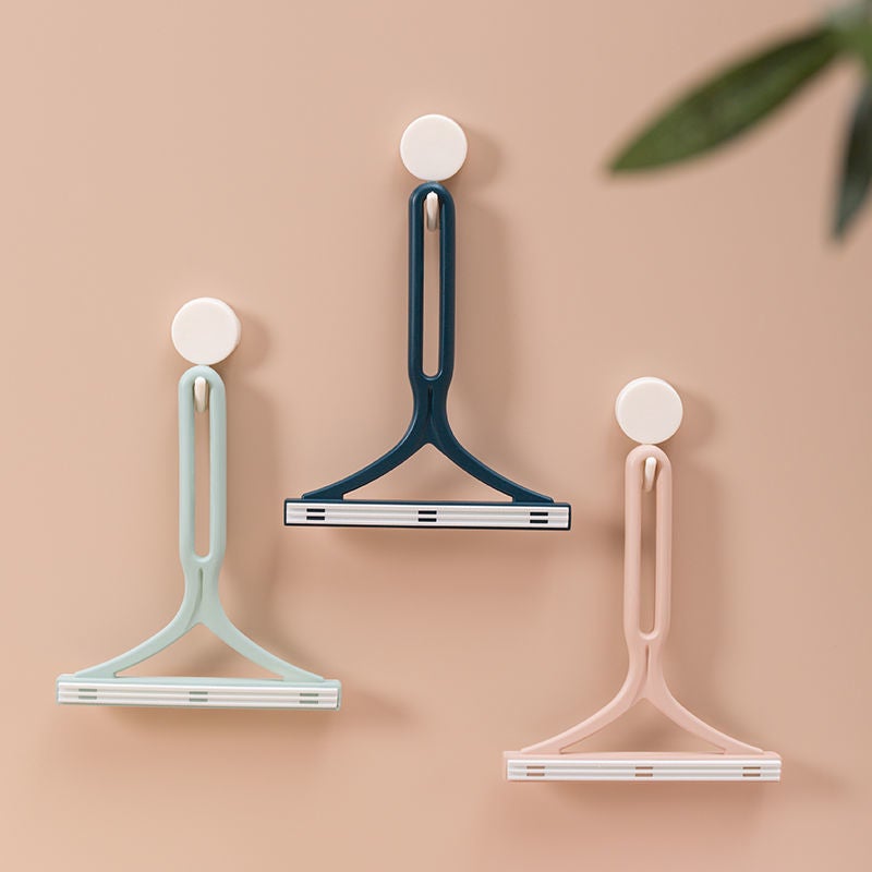 "Dubbelsidig manuell hårborttagningsapparat för kläder med ergonomiskt Y-handtag, silikonborste, grön, blå och rosa."