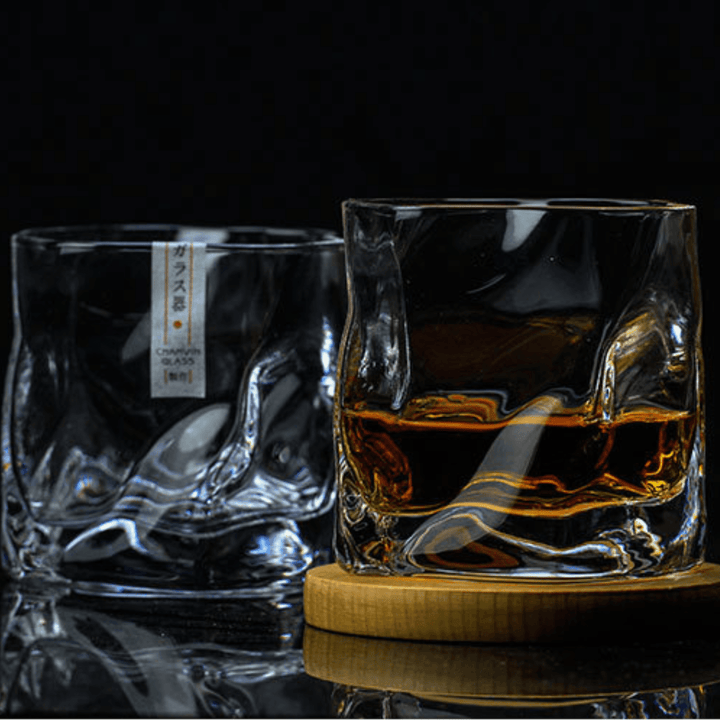Nära bild av ett handskuret Edo Kiriko whiskyglas med intrikata mönster och elegant krökt form.