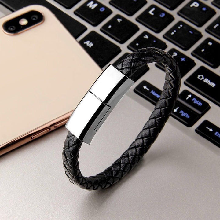"Elegant armband i svart PU-läder med integrerad laddningskabel, perfekt för modern stil och funktionalitet."