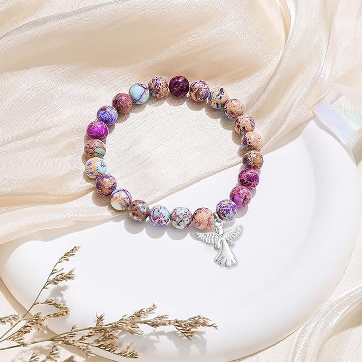 "Elegant armband med naturliga helande kristaller och subtila änglavingar för kvinnor, perfekt som gåva."
