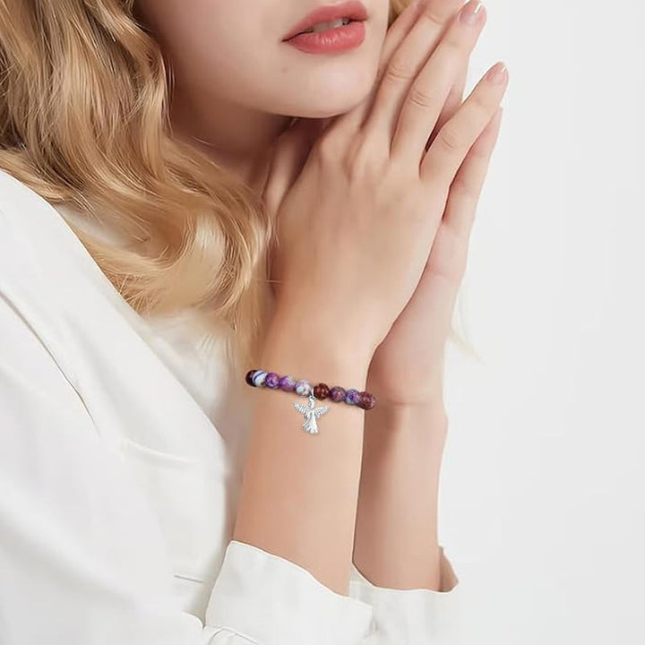 "Elegant armband med naturliga helande kristaller och subtila änglavingar för kvinnor, perfekt som gåva."