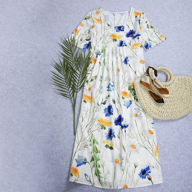 "Elegant blommig A-linje sommarklänning med rund hals i vitt, blått och gult, perfekt för sommardagar och fester."