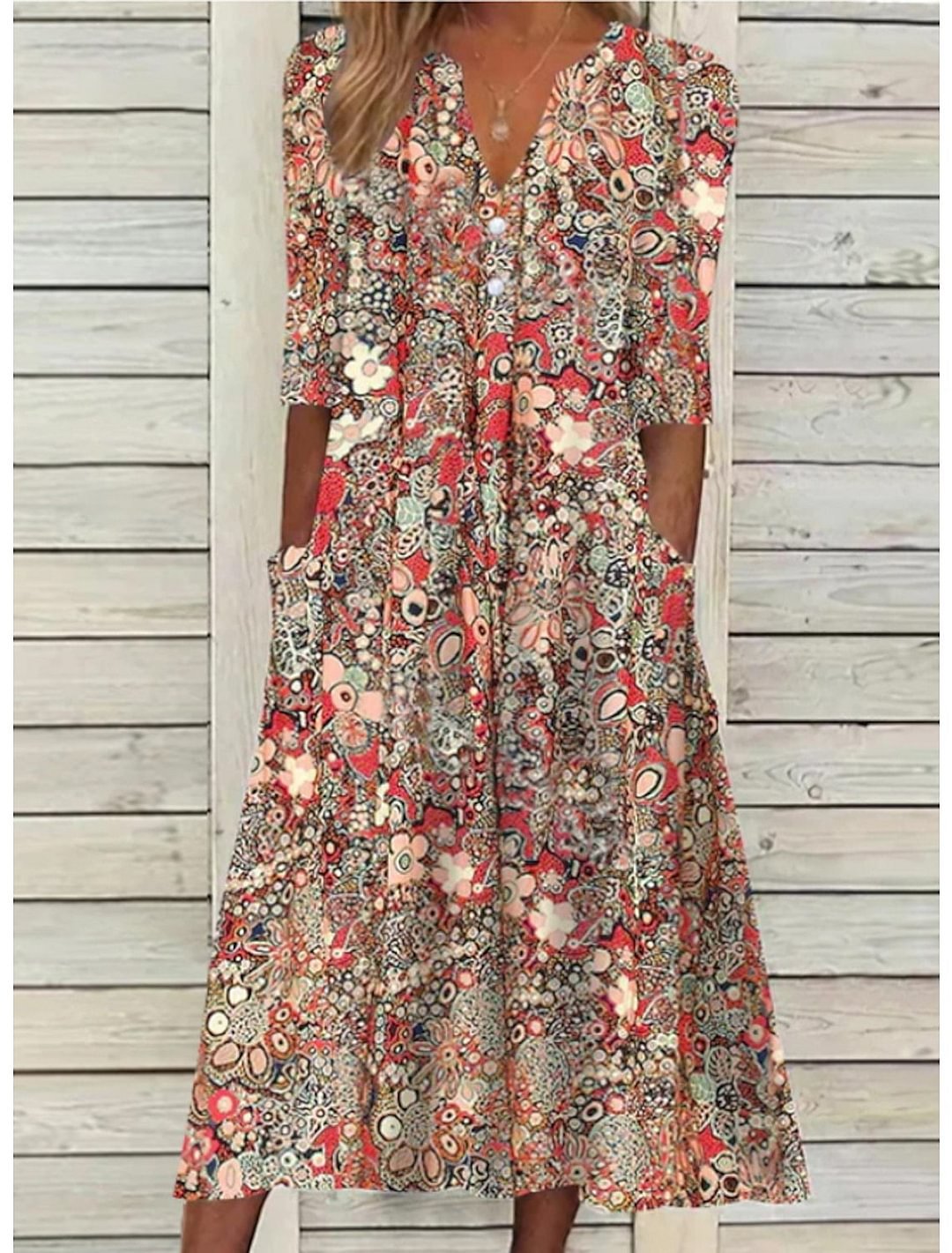 Elegant blommig damklänning med v-ringning och praktiska fickor, perfekt som sommarklänning eller vardagsklänning.