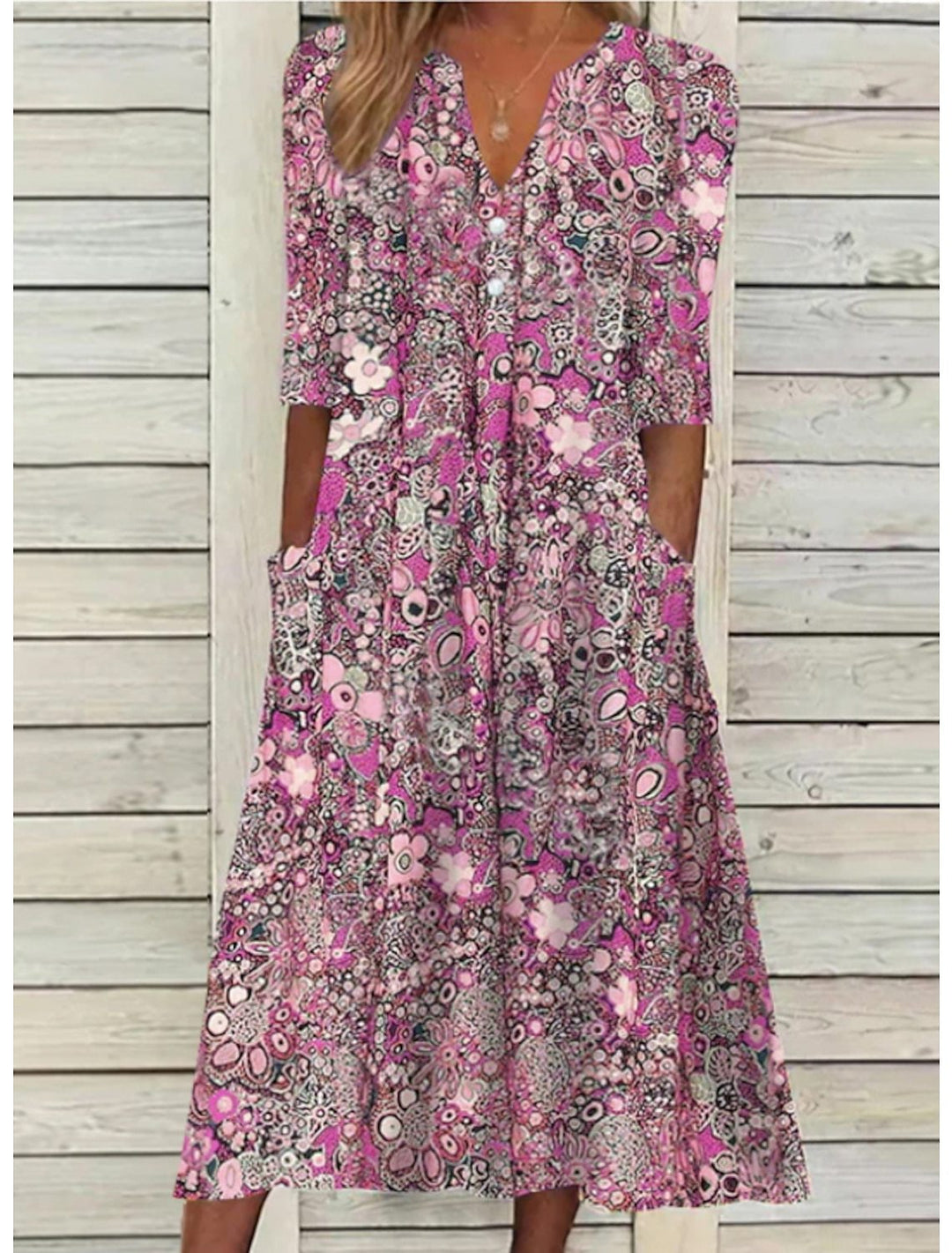Blå blommig klänning för kvinnor, med v-ringning och praktiska fickor. Passar som casual och elegant vardagsklänning.