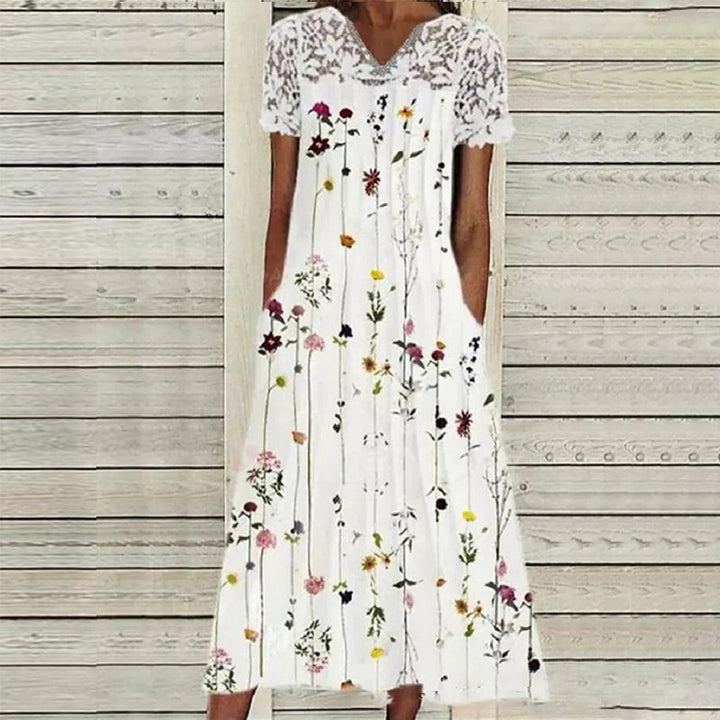 "Elegant blommig damsklänning med spetsdetaljer, perf för både vardag och fest. Midi-längd, sofistikerad look."