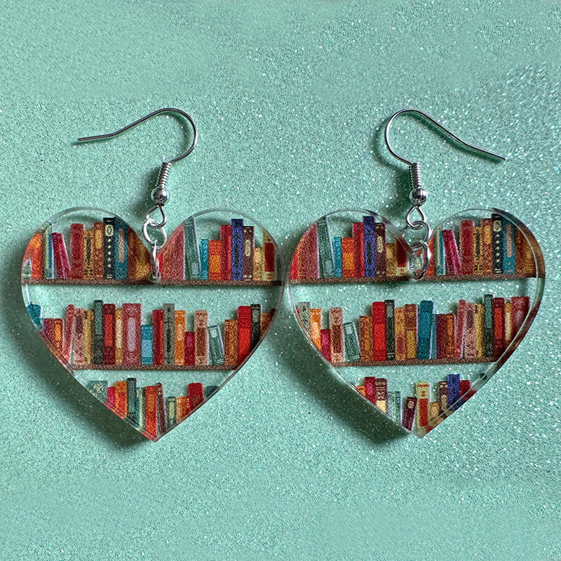 "Elegant bokörhängen i läder och silver med bokdesign, perfekta för bokälskare och som stilfulla damaccessoarer."