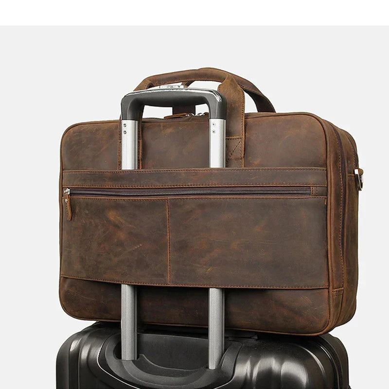 Öppen elegant läder laptopväska i brunt med rymligt huvudfack för 17-tums dator och viktiga dokument.