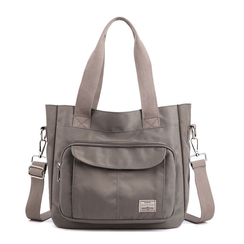"Elegant crossbody-handväska i nylon för damer, svart och slitstark, kan bäras som axelväska, justerbar rem."