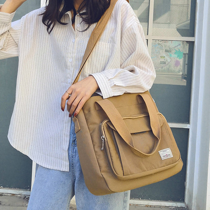 "Elegant crossbody-handväska i nylon för damer, svart och slitstark, kan bäras som axelväska, justerbar rem."