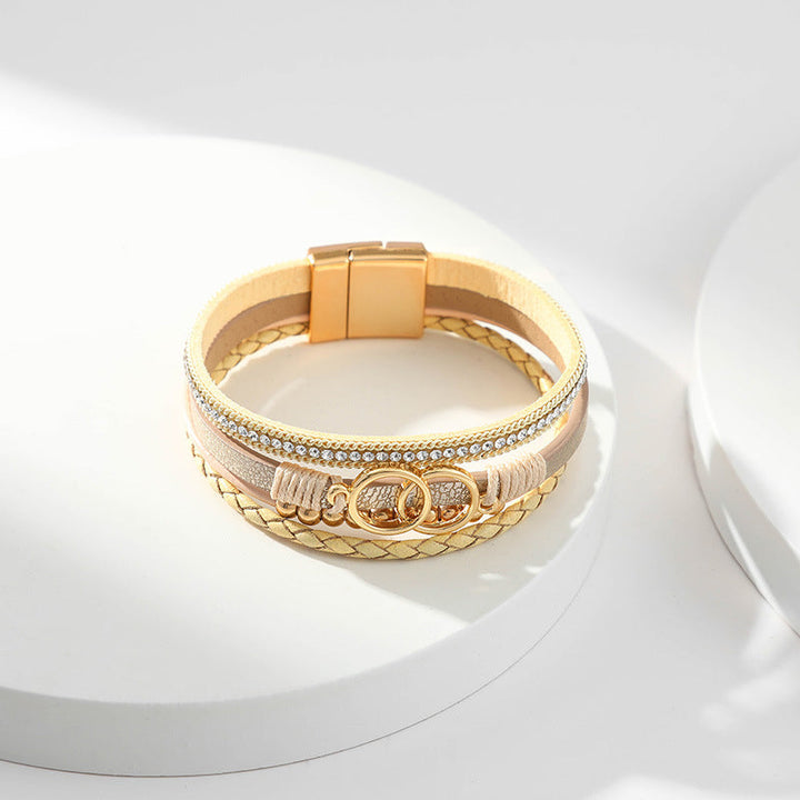 Elegant damarmband i läder, flera lager, dekorerat med guldpärlor för sofistikerad stil och justerbar komfort.
