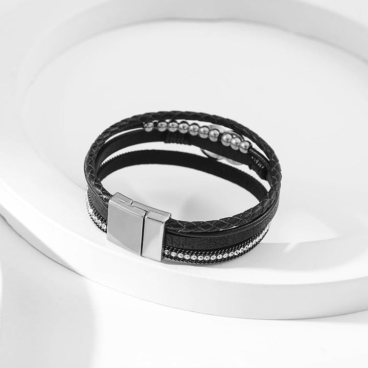 Elegant damarmband i läder, flera lager, dekorerat med guldpärlor för sofistikerad stil och justerbar komfort.