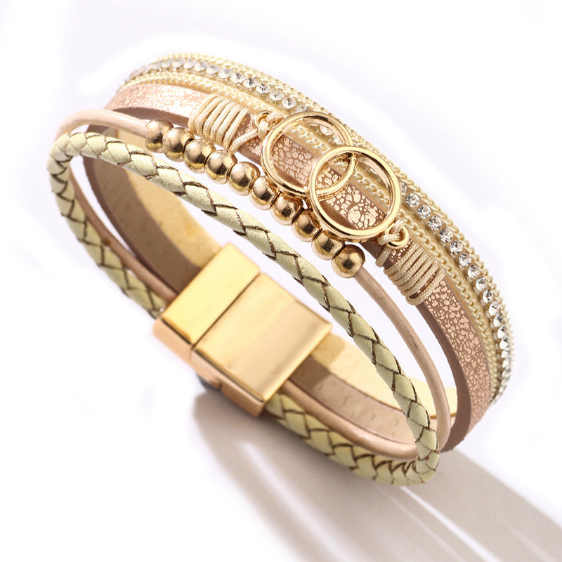 Elegant damarmband i läder, flera lager, dekorerat med guldpärlor för sofistikerad stil och justerbar komfort.