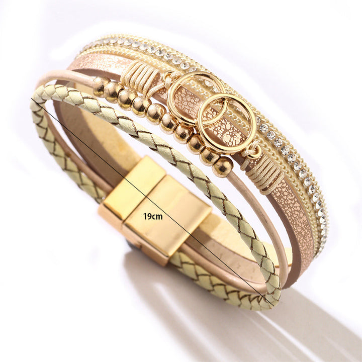 Elegant damarmband i läder, flera lager, dekorerat med guldpärlor för sofistikerad stil och justerbar komfort.